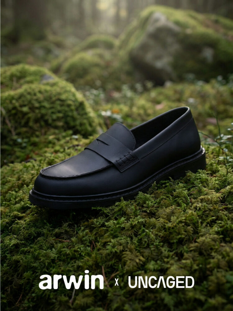 Dark leather loafer on a mossy forest floor; product shot for arwin x UNCAGED.