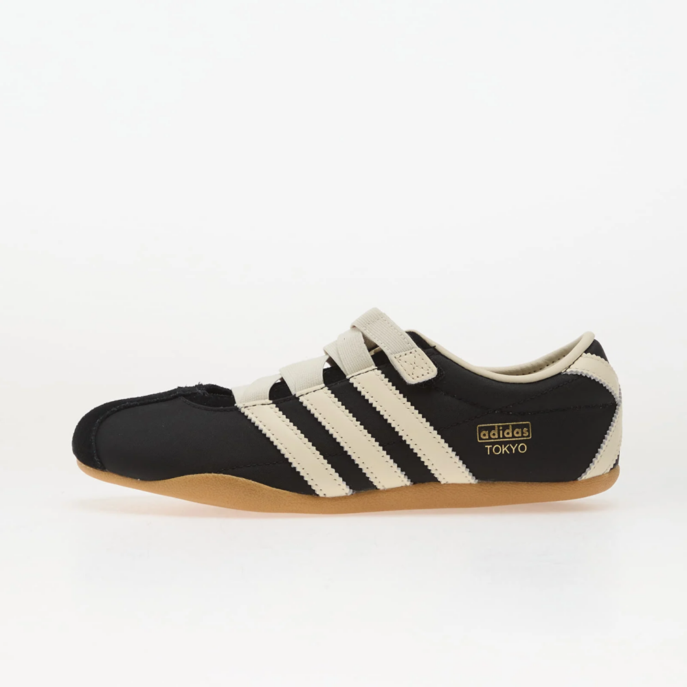Side view of a black Adidas sneaker with cream stripes and a gum sole, featuring the adidas TOKYO logo on the side, photographed on a white background.