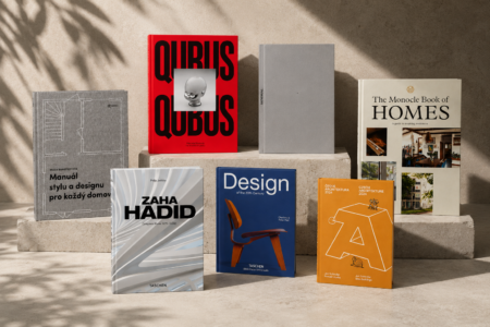 Row of design books on concrete blocks: red QUBUS, gray minimalist, and beige The Monocle Book of Homes with photos,” shadows create a studio look.